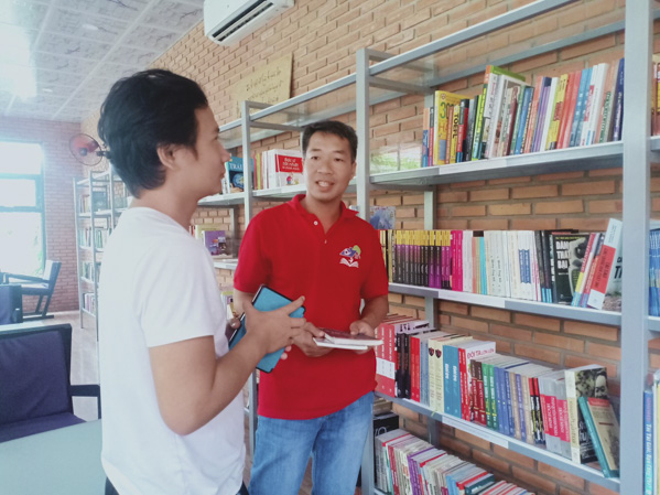 Anh Cao Huy Hoàng (bên phải) chia sẻ thông tin sách hay với bạn đọc của thư quán “Cao Gia Hòa Books and Friends”.