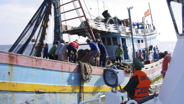 Lực lượng Biên phòng tỉnh tiếp cận một tàu cá để tuyên truyền quy định pháp luật, cách thức tránh trú bão trong quá trình đánh bắt hải sản trên biển.