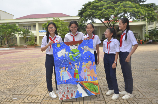 Nhóm HS lớp 8A, Trường THCS Tân Phước (TX. Phú Mỹ) vẽ bức tranh siêu anh hùng giải cứu trái đất tại hội thi. Ảnh: CẨM NHUNG