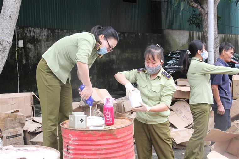 Cán bộ Cục QLTT kiểm tra mỹ phẩm giả bị thu giữ
