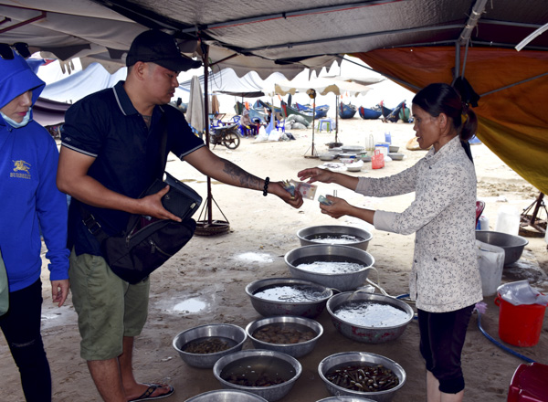 Du khách mua hải sản tại khu vực bãi biển ngã tư Hồ Tràm, xã Phước Thuận, huyện Xuyên Mộc.