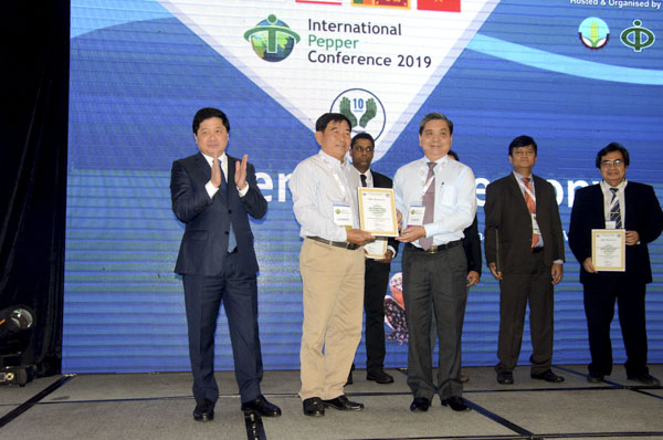 Ông Lê Quốc Doanh, Thứ trưởng Bộ NN-PTNT (bên trái) và ông Lê Tuấn Quốc, Phó Chủ tịch UBND tỉnh trao Giải thưởng nông dân trồng hồ tiêu xuất sắc năm 2018 của Hiệp hội Hồ tiêu quốc tế cho nông dân Phan Văn Lý (Bình Phước).