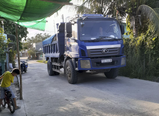 Xe vận chuyển vật liệu đi vào đường khu dân cư Dòng Than, thôn Cát Hải, xã Tân Hải có biển cấm xe có tải trọng trên 8 tấn lưu thông.