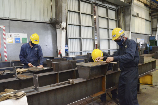 Công nhân Công ty TNHH MTV Kết cấu thép PEB kiểm tra các số đo của khung nhà tiền chế thép tại xưởng. 