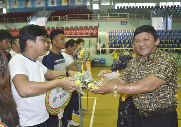 Ông Đặng Văn Cường, Giám đốc Trung tâm HL&TĐ TDTT tỉnh trao hoa và cờ lưu niệm cho các đơn vị về dự giải.