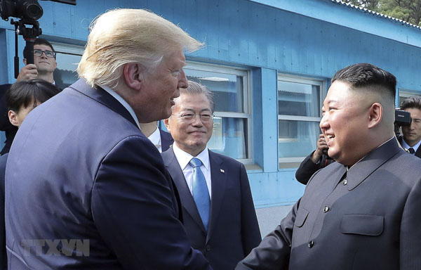 Tổng thống Mỹ Donald Trump (trái), nhà lãnh đạo Triều Tiên Kim Jong-un (phải) và Tổng thống Hàn Quốc Moon Jae-in (giữa) trong cuộc gặp tại Khu phi quân sự (DMZ) ngày 30/6. (Nguồn: AFP)