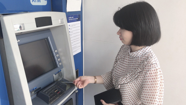 Người dân rút tiền tại máy ATM của NCB.