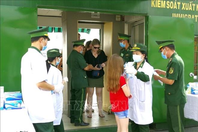 Cán bộ y tế Bộ đội Biên phòng TPHCM kiểm tra y tế và phát khẩu trang miễn phí cho du khách tàu Odyssey-Nassau (Hoa Kỳ) cập cảng Bến Nghé. Ảnh: TTXVN