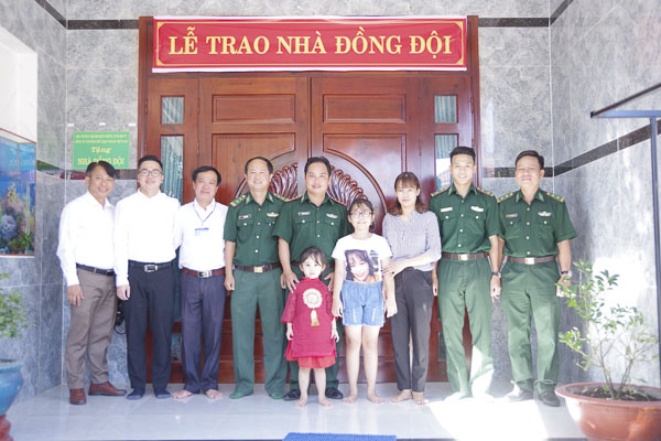 Đại diện Bộ đội Biên phòng tỉnh, chính quyền địa phương và nhà tài trợ cùng gia đình Thượng úy Trương Đức Quân trong lễ bàn giao nhà.