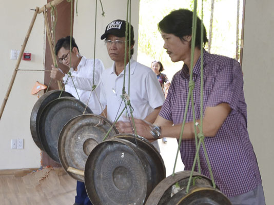 Các hội viên Ban Âm nhạc tìm hiểu về bộ cồng, chiêng của đồng bào Châu Ro, được trưng bày tại Nhà Văn hóa dân tộc Bàu Chinh.