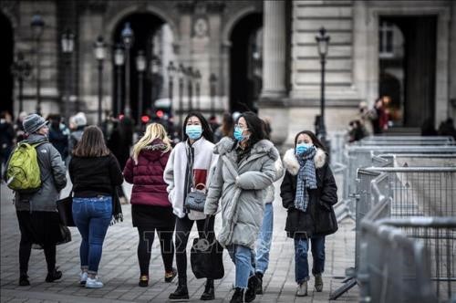 Người dân và du khách đeo khẩu trang phòng tránh lây nhiễm COVID-19. Ảnh: AFP/TTXVN
