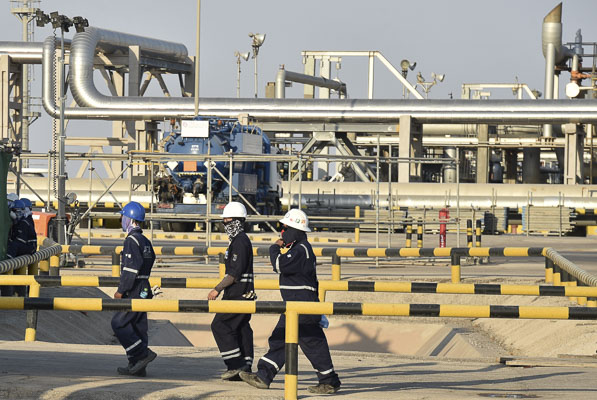 Công nhân công ty dầu Aramco  làm việc tại nhà máy chế dầu Abqaiq  của Saudi Arabia. 