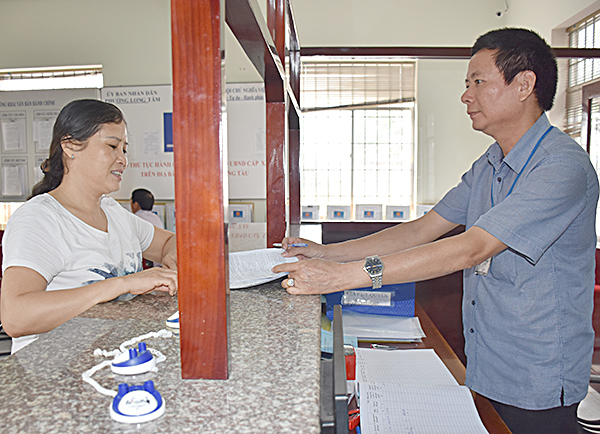 Công chức bộ phận một cửa phường Long Tâm tiếp nhận và hướng dẫn người dân làm thủ tục hành chính.