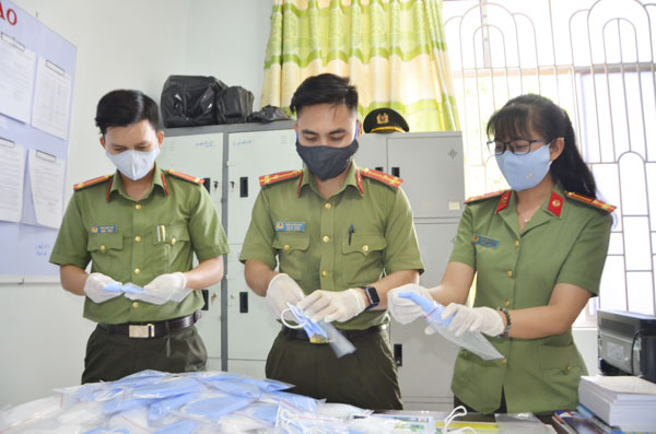 Thượng úy Trần Hoàng Linh (giữa) chuẩn bị khẩu trang vải kháng khuẩn tặng người dân.