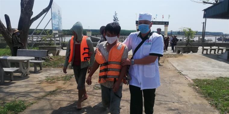 Lực lượng biên phòng phối hợp với tàu cá đưa các ngư dân bị nạn vào bờ, kiểm tra sức khỏe. 