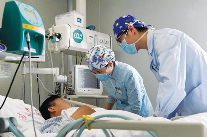 Nhân viên y tế chăm sóc bệnh nhân tại bệnh viện ở Trung Quốc.  Ảnh: SINA