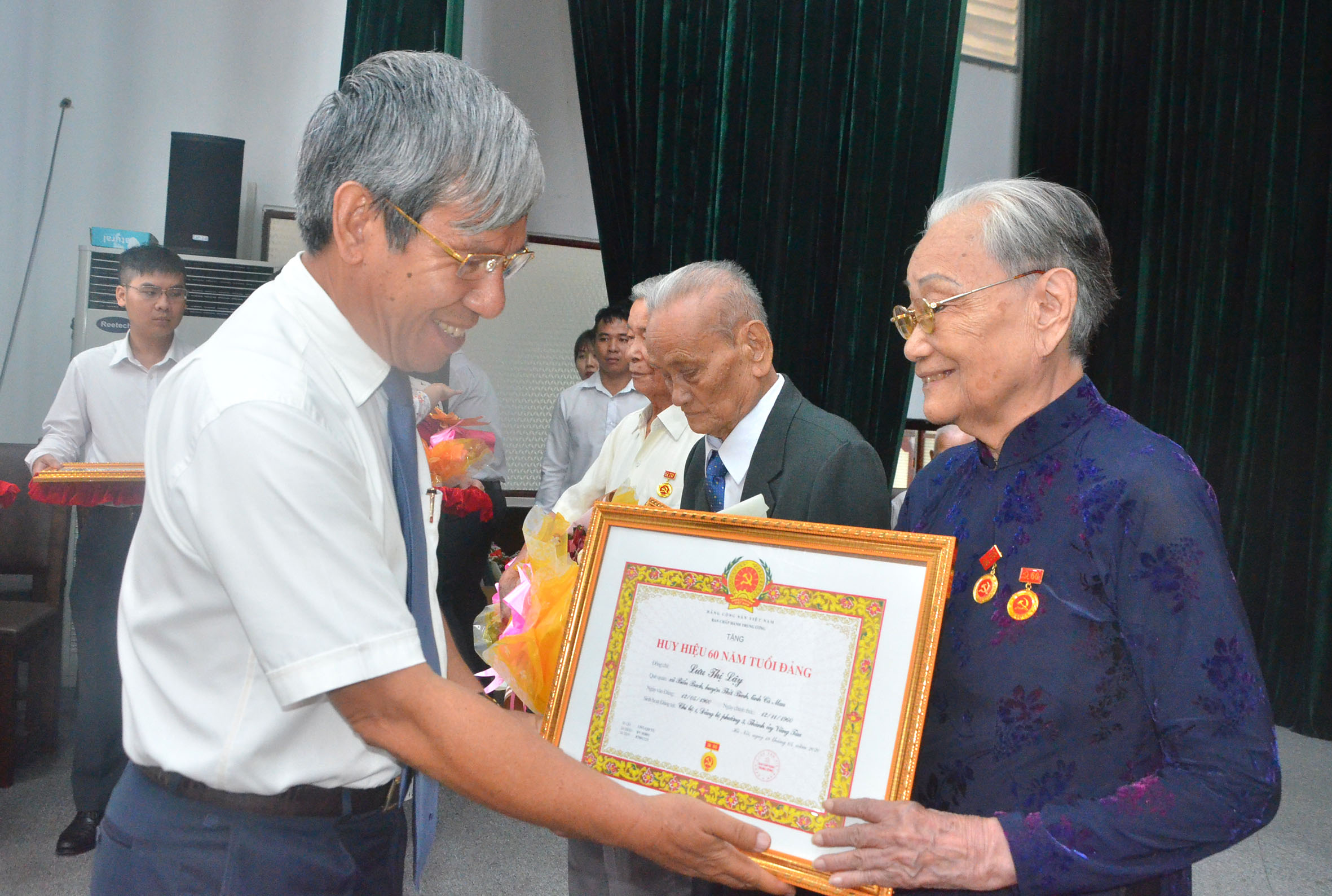 Ông Nguyễn Lập, Tỉnh ủy viên, Chủ tịch UBND TP.Vũng Tàu trao Huy hiệu 60 tuổi Đảng cho các đảng viên.
