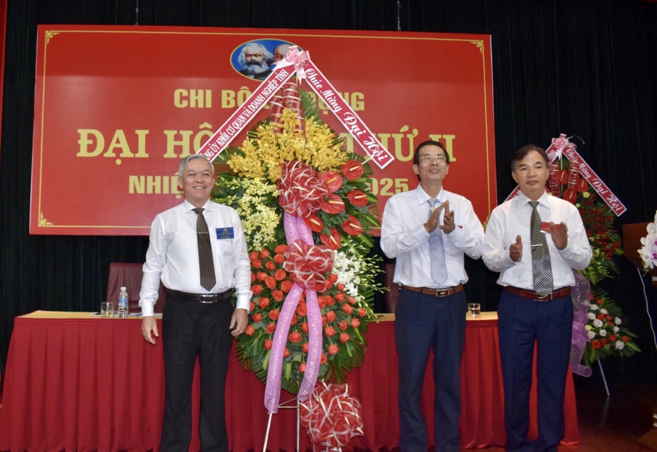 Đồng chí Hoàng Minh Kim (bìa trái), Phó Bí thư Thường trực Đảng ủy Khối Cơ quan và DN tỉnh tặng hoa chúc mừng Đại hội. 