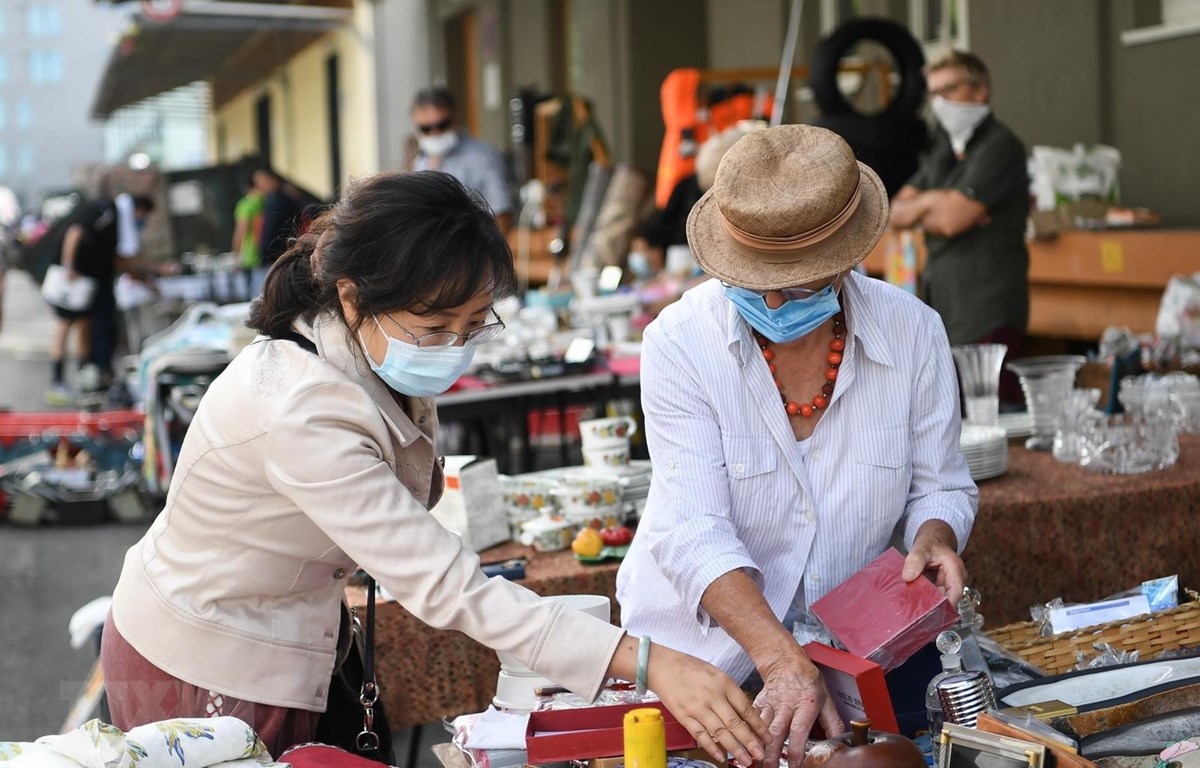 Người dân đeo khẩu trang phòng lây nhiễm COVID-19  tại một khu chợ ở Frankfurt, Đức. 