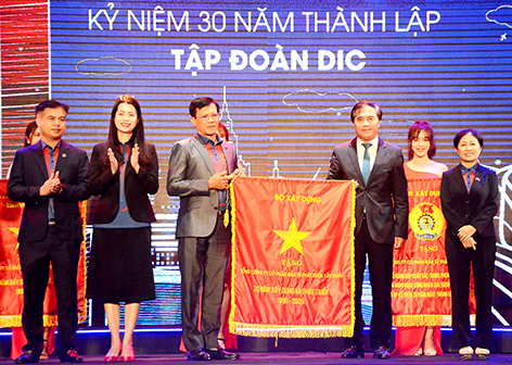 Đồng chí Lê Quang Hùng, Thứ trưởng Bộ Xây dựng (phải) trao bức trướng của Bộ Xây dựng tặng DIC Corp nhân kỷ niệm 30 năm xây dựng và phát triển. Ảnh: VÂN ANH