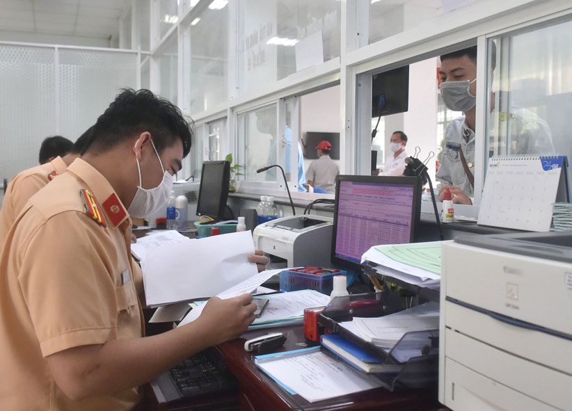 Cán bộ Đội Đăng ký, Phòng CSGT (PC08)-Công an tỉnh tiếp nhận hồ sơ của người dân.
