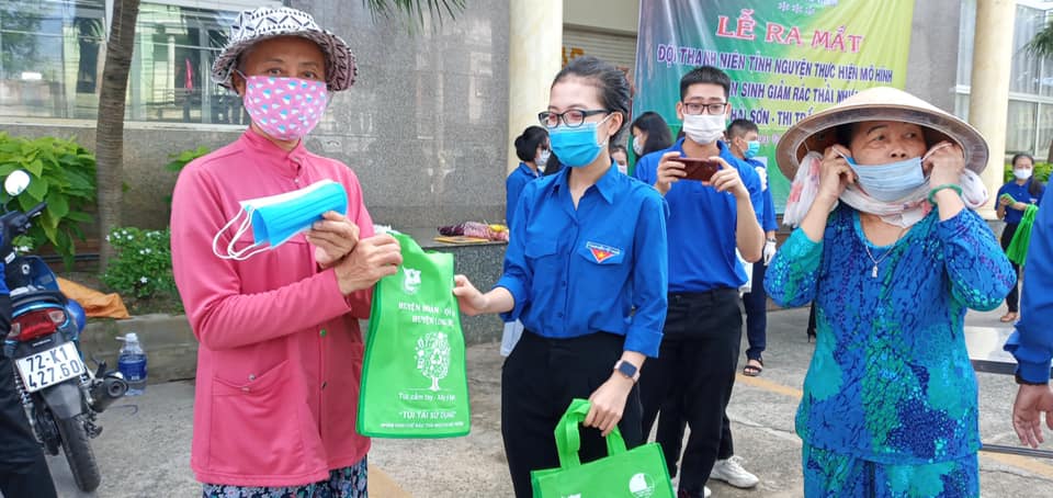 Đoàn viên thanh niên phát tờ rơi tuyên truyền phòng, chống rác thải nhựa và khẩu trang y tế và túi vải cho người dân đến mua sắm tại chợ Hải Sơn.