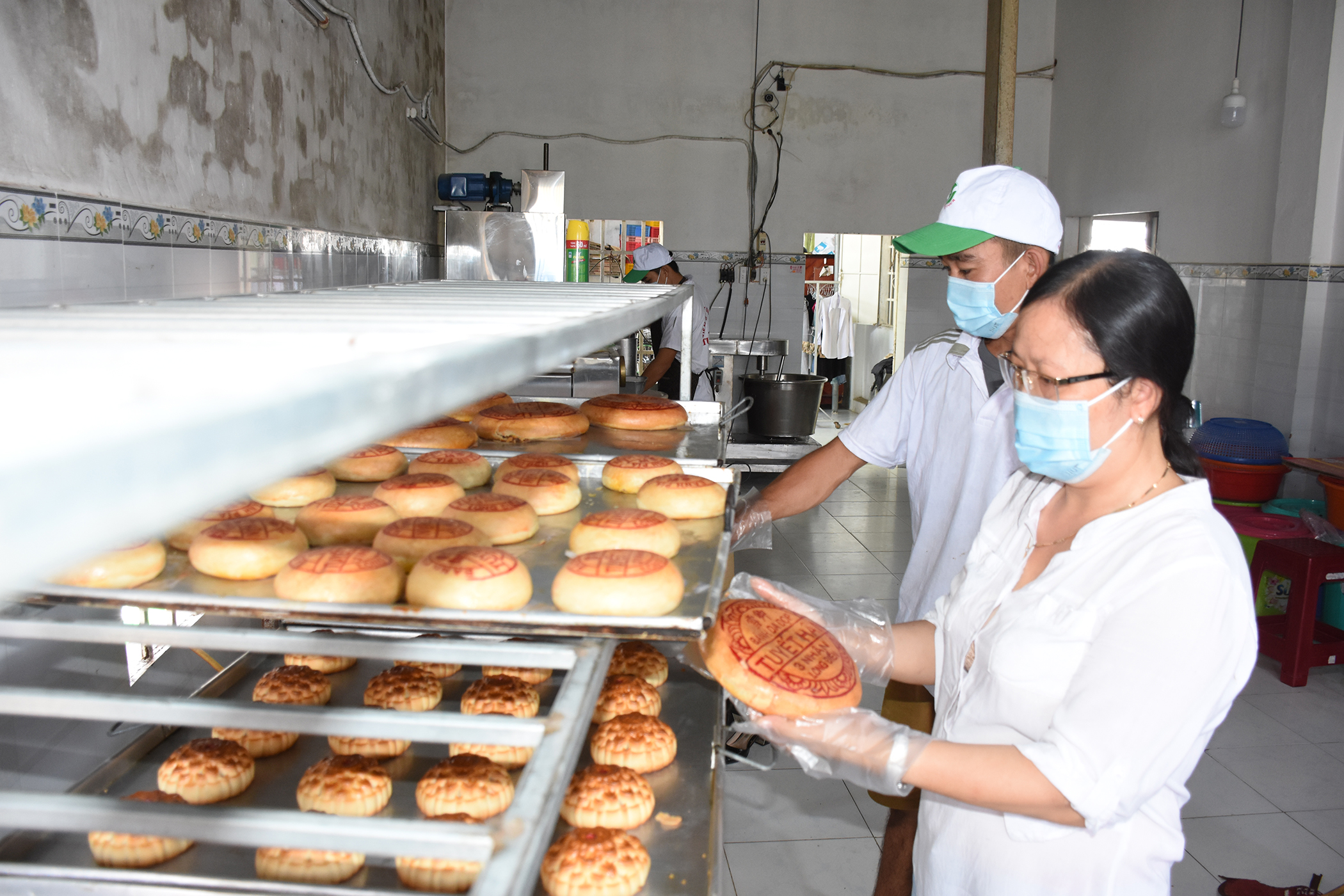 Chị Lê Thị Thọ Sương, chủ cơ sở bánh Trung thu Tuyết Hân trực tiếp kiểm tra từng chiếc bánh Trung thu sau khi nướng.
