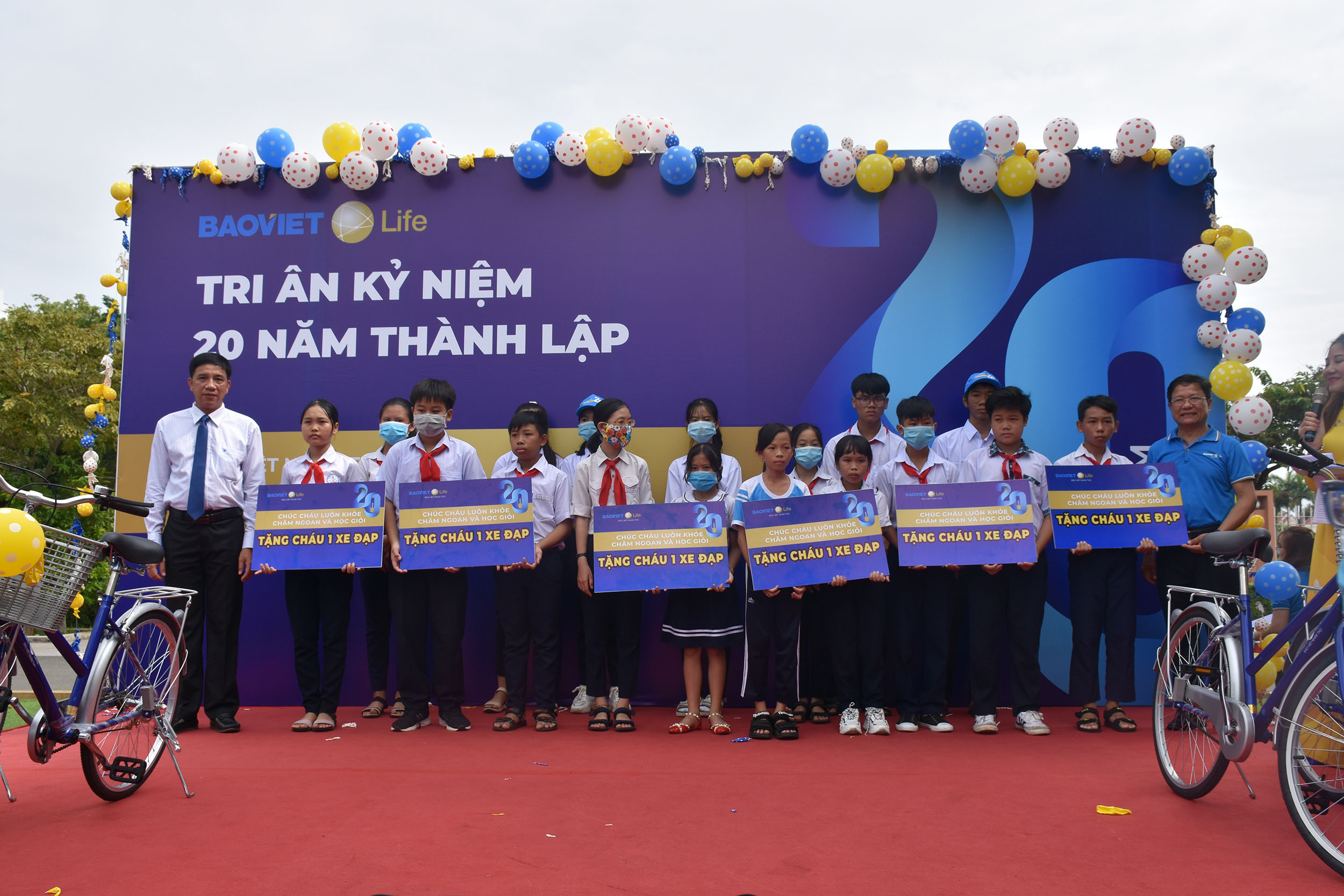 Ông Trần Quốc Khánh (bìa trái), Phó Giám đốc Sở LĐTBXH và ông  Phan Thanh Tuấn (bìa phải), Giám đốc Công ty Bảo Việt Nhân thọ BR-VT trao tặng xe đạp cho các em học sinh nghèo vượt khó hiếu học