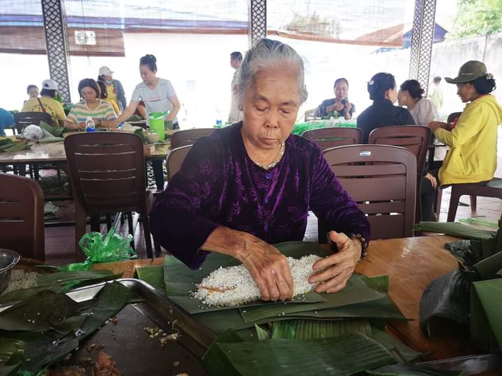 Bà Nguyễn Thị Dư (khu phố Phú Hà, phường Mỹ Xuân) cẩn thận gói từng chiếc bánh tét gửi bà con vùng lũ. Ảnh: NGÔ CHIẾN