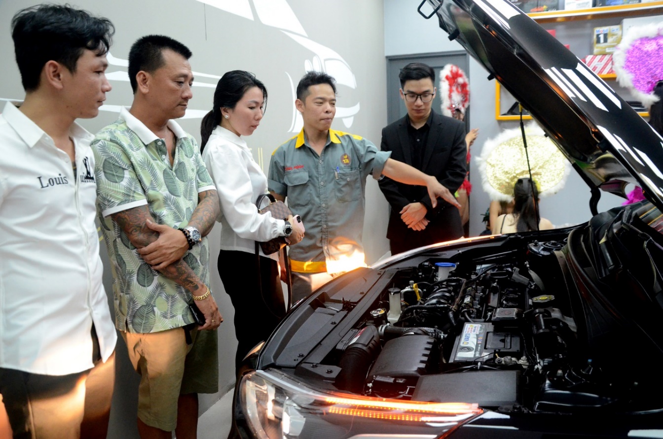 Nhân viên T3 Auto Care giới thiệu cho khách hàng một số chi tiết máy xe trong lễ khai trương.
