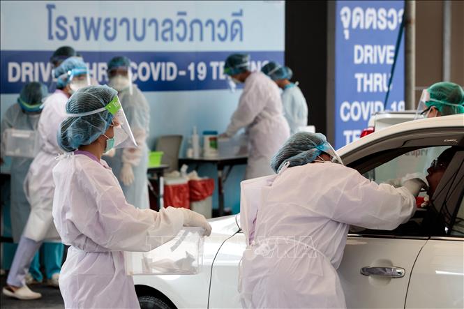 Nhân viên y tế lấy mẫu xét nghiệm COVID-19 tại trạm xét nghiệm ở Bangkok, Thái Lan. Ảnh tư liệu: AFP/TTXVN