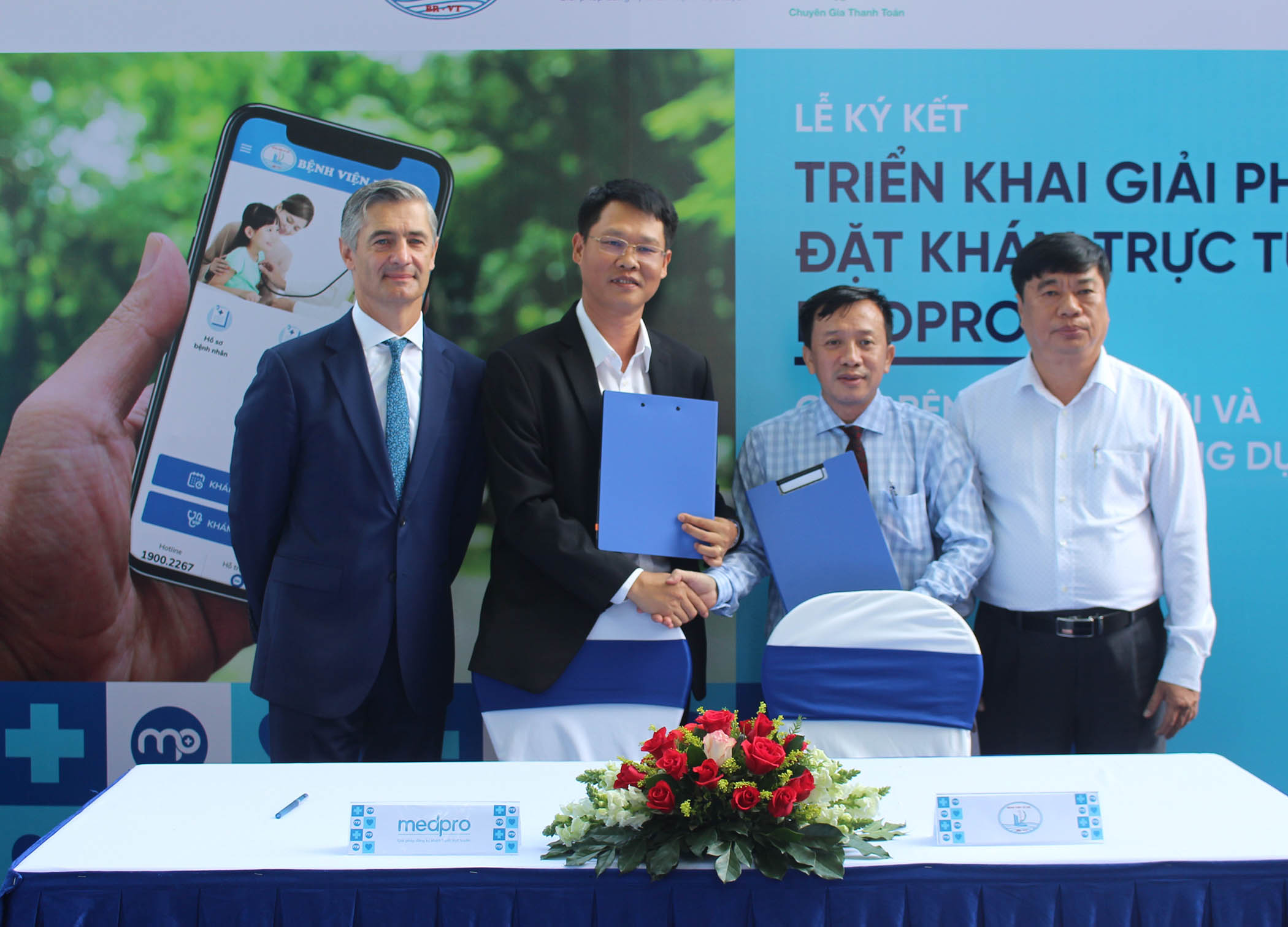 Bác sĩ Nguyễn Thanh Phước, Giám đốc Bệnh viện Lê Lợi (thứ 2 bìa phải) và ông Bùi Triệu Anh Tuấn, Tổng Giám đốc Công ty CP Ứng dụng PKH (thứ 2 bìa trái) ký kết biên bản hợp tác triển khai giải pháp đặt lịch khám trực tuyến MedPro giữa 2 đơn vị.