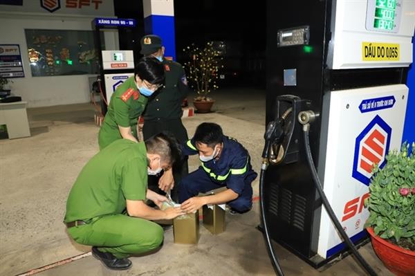 Lấy mẫu giám định chất lượng xăng.