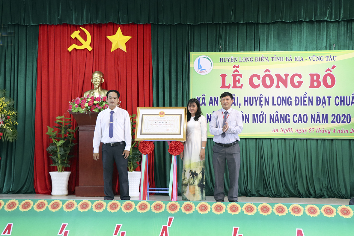 Thừa ủy quyền của Chủ tịch UBND tỉnh, ông Đỗ Minh Tuấn (bên trái), Phó Giám đốc Sở NN&PTNT trao Bằng công nhận xã đạt chuẩn NTM nâng cao cho xã An Ngãi.