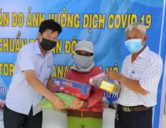 Ông Phạm Văn Bình (trái), Chủ tịch UBMTTQVN phường Tân Phước, tặng quà hỗ trợ hộ khó khăn trên địa bàn.