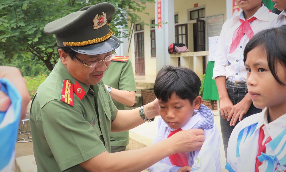 Đại tá Hồ Văn Tứ - Phó Giám đốc Công an Nghệ An tặng quà cho các em học sinh Trường Tiểu học và THCS xã Bảo Thắng, huyện Kỳ Sơn. Ảnh: Trọng Tuấn