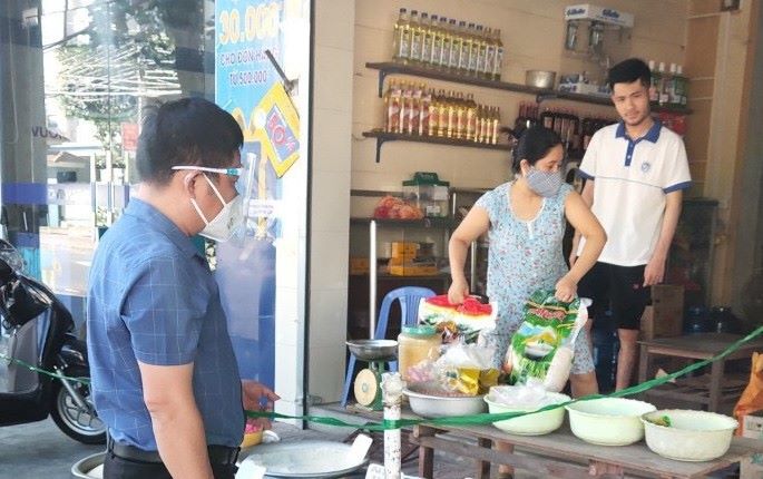Kiểm tra việc chấp hành các quy định phòng chống dịch tại một cửa hàng bán đồ thiết yếu