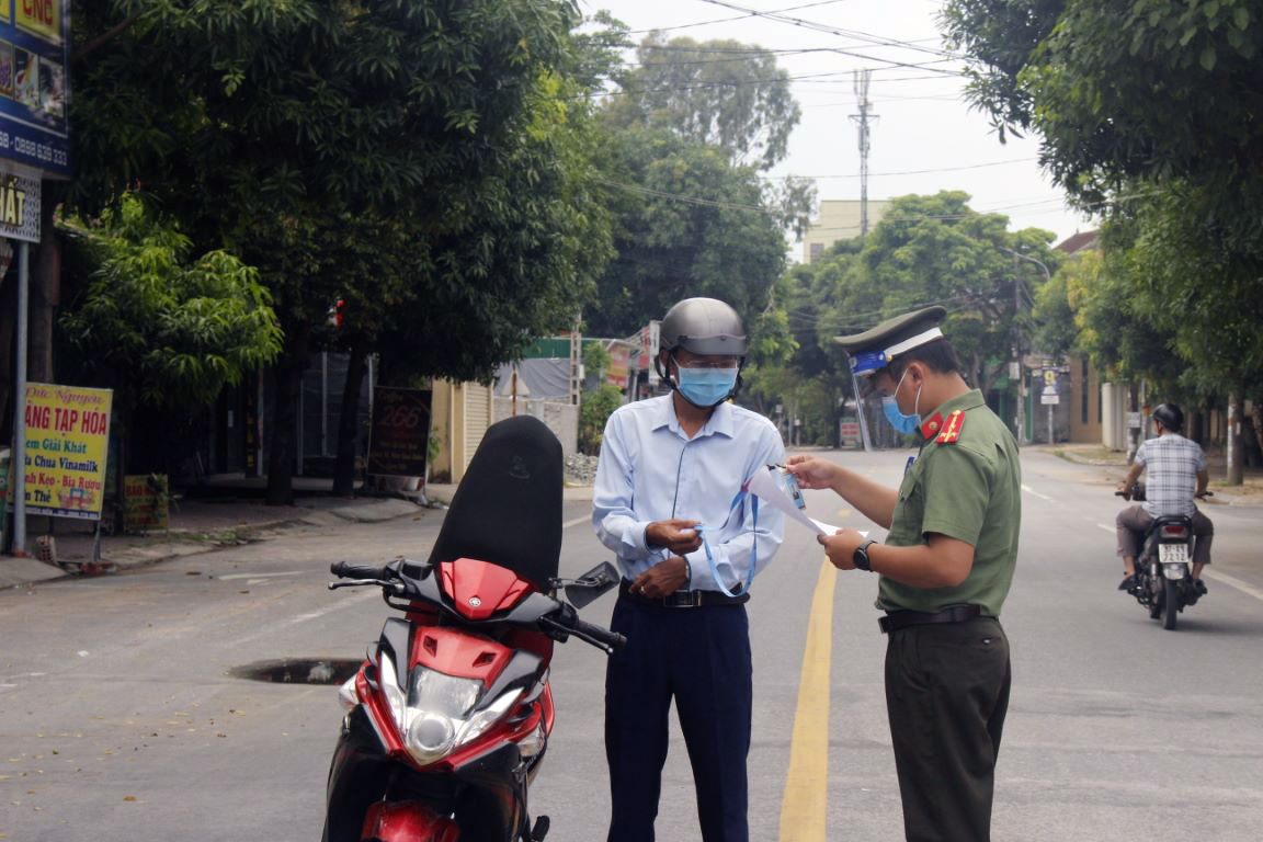 Cán bộ Phòng An ninh chính trị nội bộ Công an Nghệ An kiểm tra giấy ra đường của một người dân tại một điểm chốt