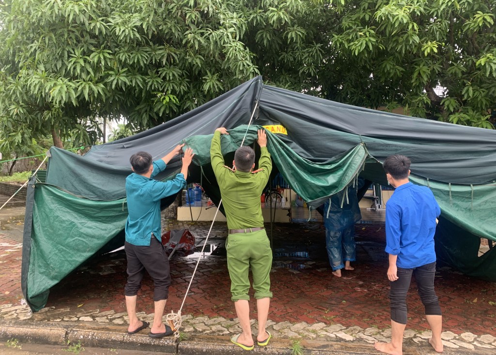 Lực lượng làm nhiệm vụ tại khu vực vòng xuyến Cửa Hội dựng lại nhà bạt bị sập do mưa lớn kéo dài từ đêm 05/10/2021 đến sáng 06/10/2021 
