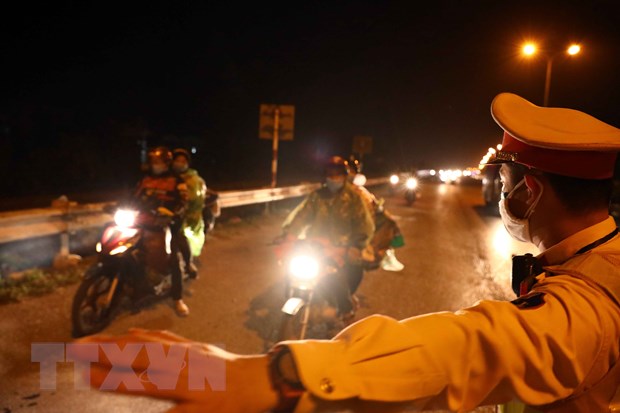 Lực lượng Cảnh sát giao thông hướng dẫn, phân luồng đoàn xe của người dân đi từ các tỉnh phía Nam về quê qua địa bàn Hà Nội. (Ảnh: TTXVN