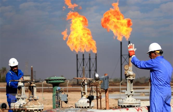 Công nhân làm việc tại một cơ sở khai thác dầu ở Basra (Iraq).