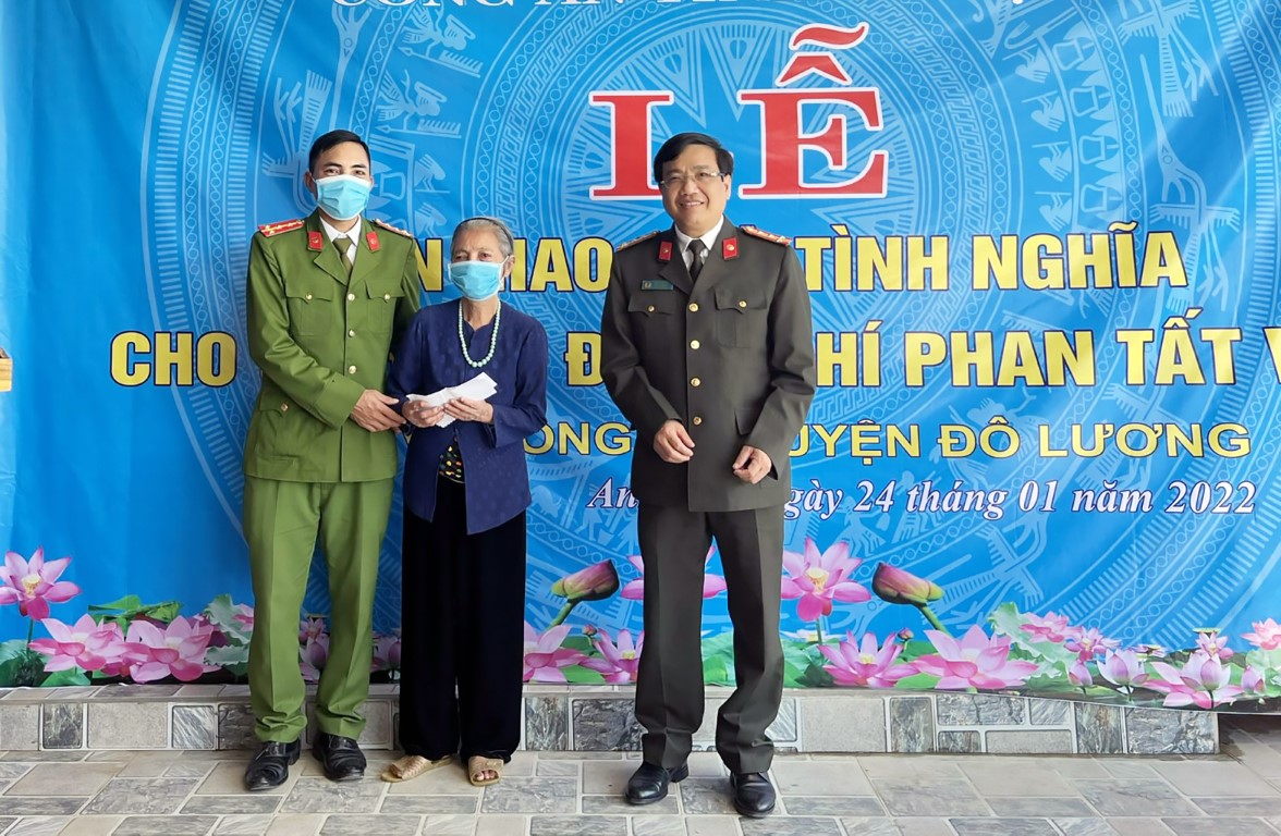 Đồng chí Đại tá Hồ Văn Tứ, Phó Giám đốc, Chủ nhiệm UBKT Đảng ủy Công an tỉnh trao quà của Cơ quan UBKT Đảng ủy Công an tỉnh cho đồng chí Phan Tất Việt, Công an viên xã Quang Sơn, huyện Đô Lương