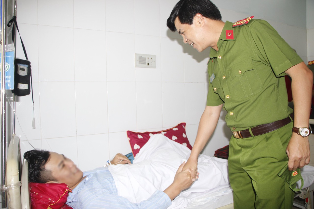 Đồng chí Đại tá Nguyễn Đức Hải, Phó Giám đốc, Thủ trưởng Cơ quan Cảnh sát điều tra, Công an tỉnh thăm hỏi tình hình sức khỏe đồng chí T. Ảnh: Văn Hậu