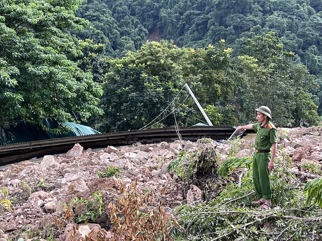 Thiếu tá Phan Văn Tùng, Trưởng Công an xã Tà Cạ bên cạnh trụ sở vừa bị đổ sập do lũ quét