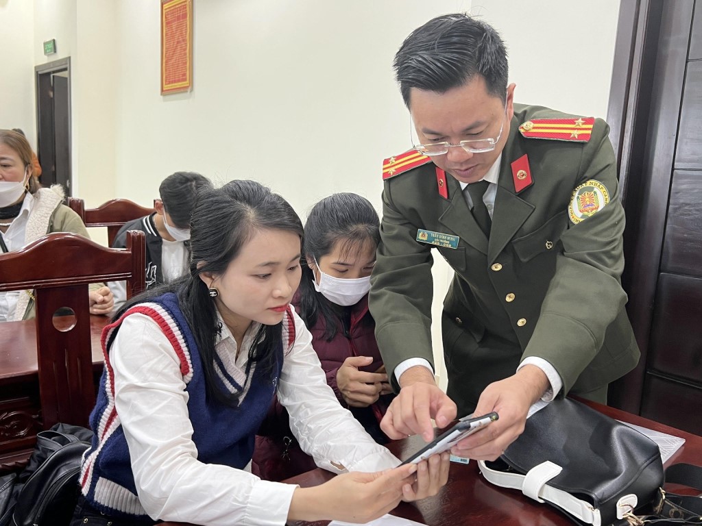 Cán bộ hướng dẫn công dân tải ứng dụng VNeID để đăng kí tài khoản định danh điện tử