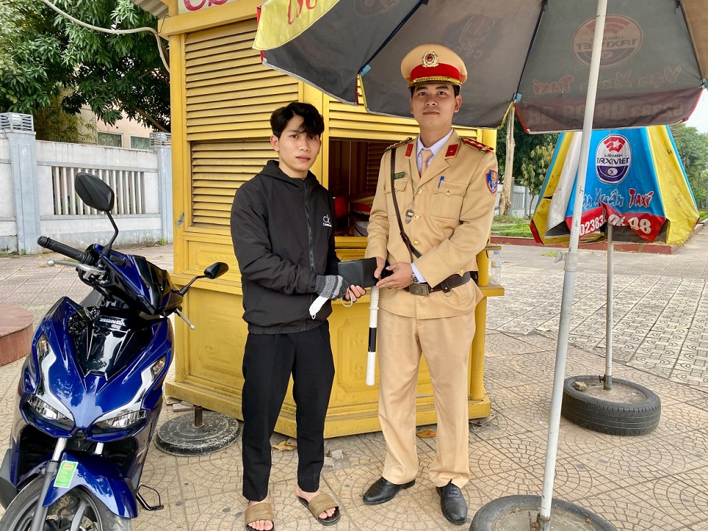 Anh Nguyễn Hữu Hoàng nhận lại chiếc ví đánh rơi từ các chiến sỹ Cảnh sát giao thông thành phố Vinh