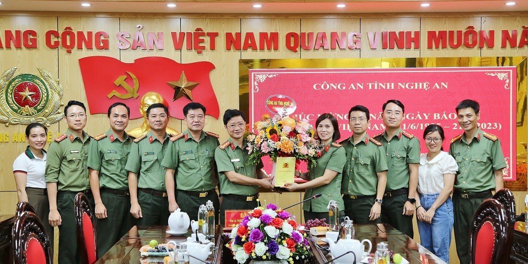 Đồng chí Đại tá Trần Ngọc Tuấn - Phó Giám đốc Công an tỉnh tặng hoa chúc mừng đội ngũ cán bộ, phóng viên làm công tác tuyên truyền trong Công an Nghệ An