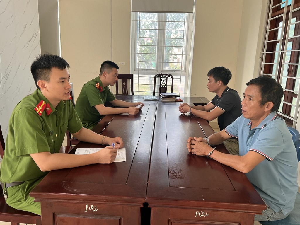 Cán bộ Phòng Cảnh sát hình sự (Công an Nghệ An) làm việc với 02 đối tượng truy nã bị bắt giữ.