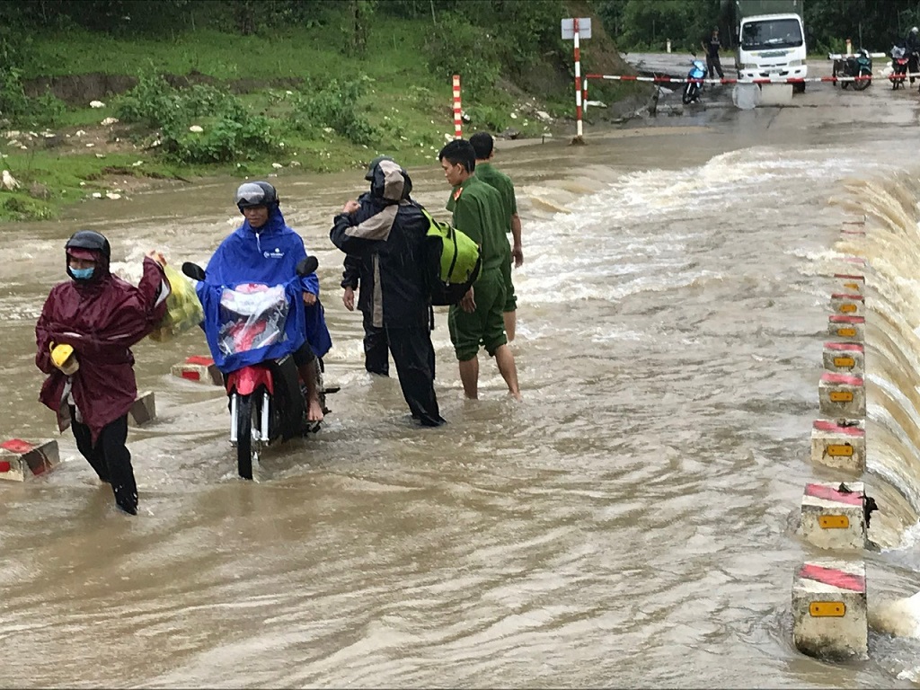 Lực lượng Công an hỗ trợ người dân di chuyển qua đập tràn