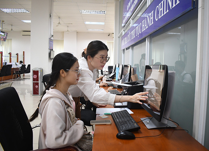 Công chức hướng dẫn người dân thực hiện dịch vụ công trực tuyến tại Trung tâm Phục vụ hành chính công tỉnh.